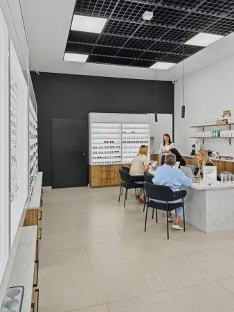 Stylista opraw okularowych podczas doboru okularów w salonie VisionOptyk w Lesznie