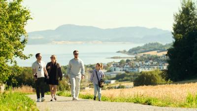 Områdespesialist som går tur i nærområde sammen med barnefamilie.