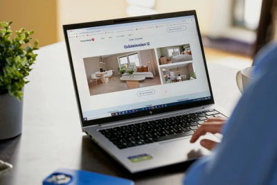 Foto av person bakfra som ser på en PC-skjerm med boligannonse.