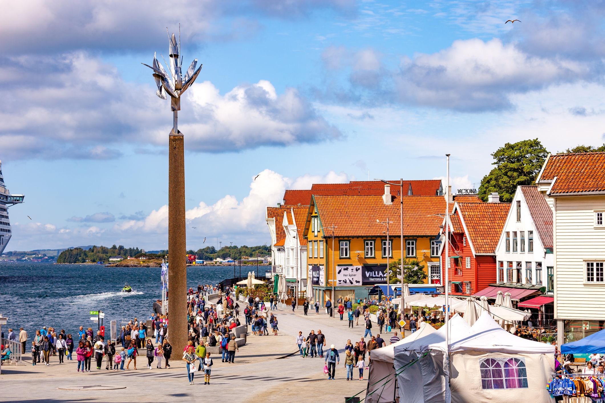 Foto fra Vågen i Stavanger, med hvite, gule og røde hus, og masse mennesker.