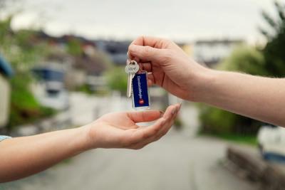 Overlevering av nøkkelknippe mellom to hender. Foto.