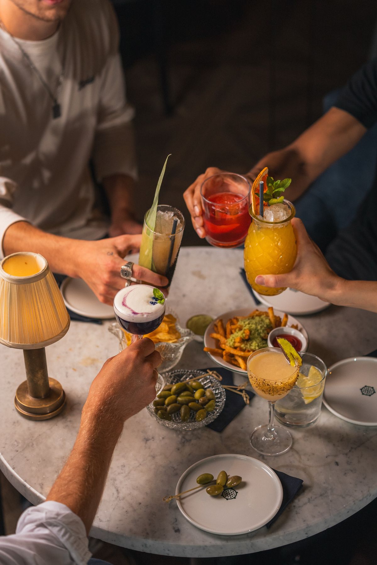 Gjester som skåler med cocktails og burgere på Kverneriet