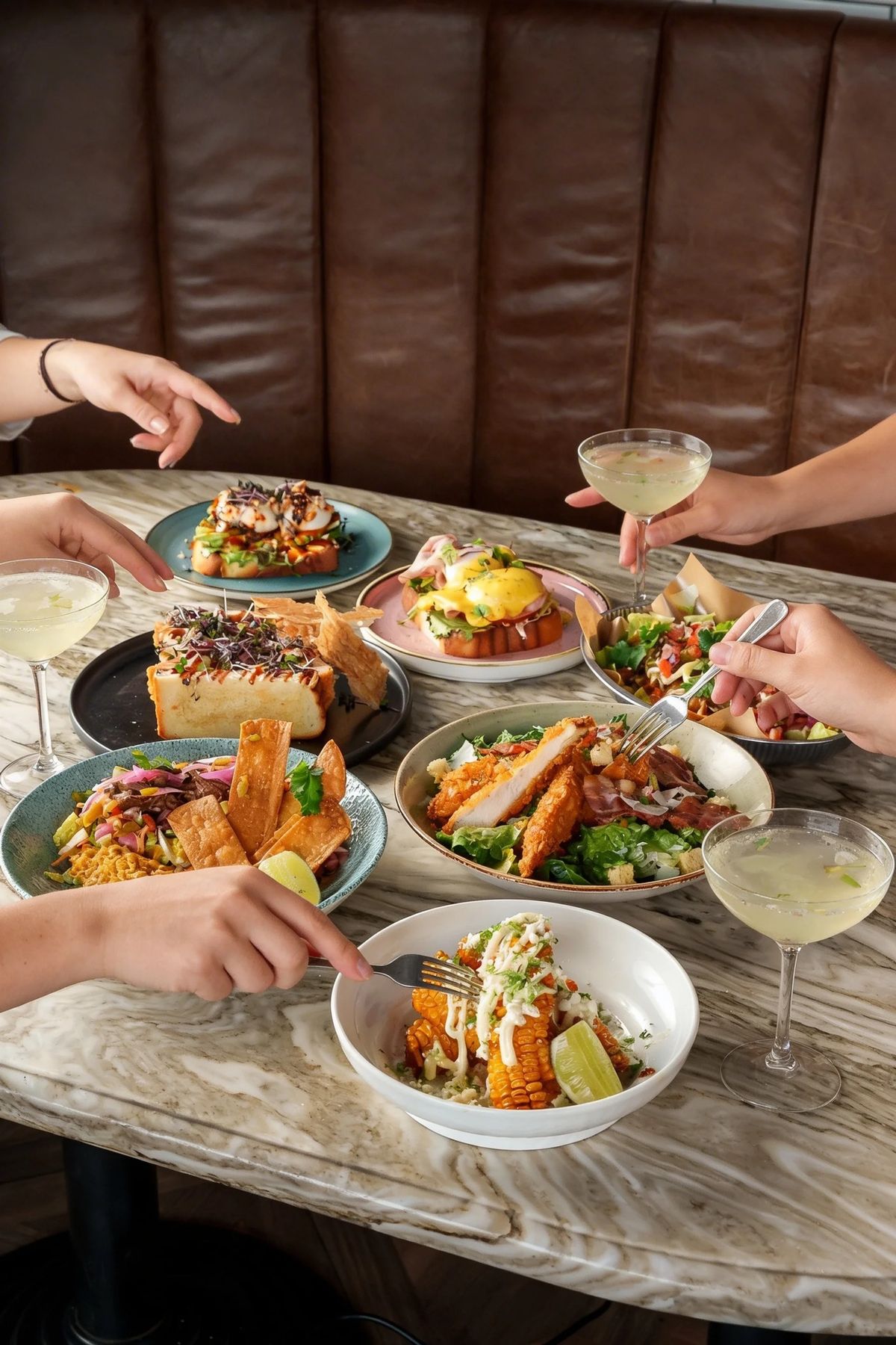 Lunsjbord med salater, toast, eggs benedict og cocktails på Kverneriet Tønsberg
