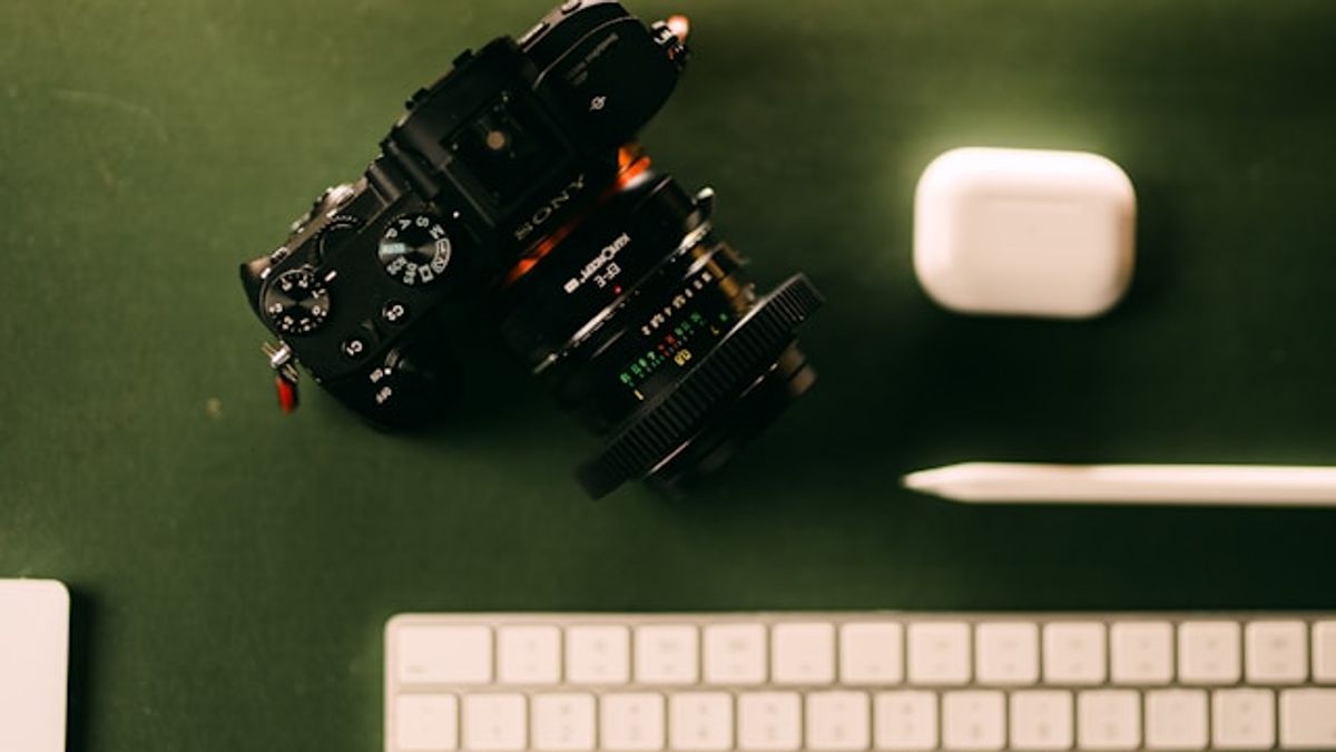 A DSLR camera placed on a desk next to a modern keyboard, symbolizing content creation and digital marketing tools.