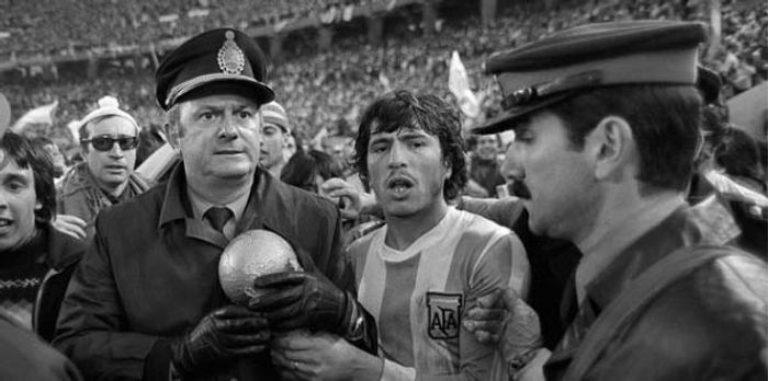 1978년 월드컵 경기장에서 우승컵을 끌어안고 있는 군인과 축구선수
