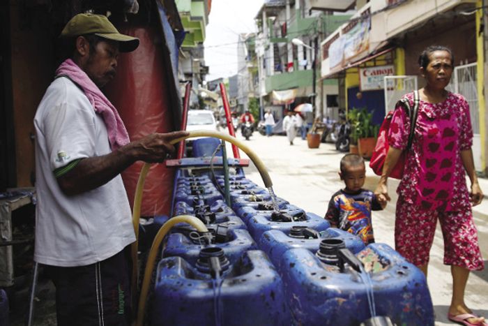 수도시설 부족으로 자카르타 물 충전 상점에서 배달하기 위한 물을 채우는 상수도업체 직원