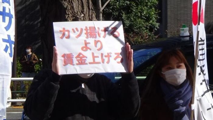 가쓰야 본사 앞에서 손팻말을 들고 있는 노동자