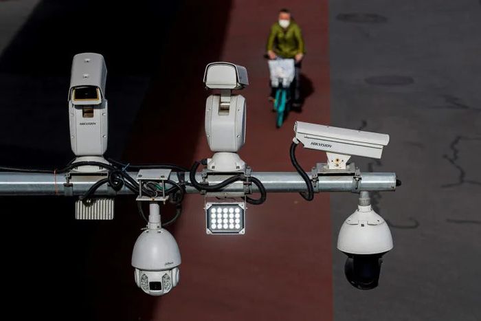 Hikvision and Dahua CCTV security surveillance cameras overlook a street as a man cycles past following the spread of the coronavirus disease (COVID-19) in Beijing, China May 11, 2020. Picture taken May 11, 2020. REUTERS/Thomas Peter – RC26WG9OWA4V