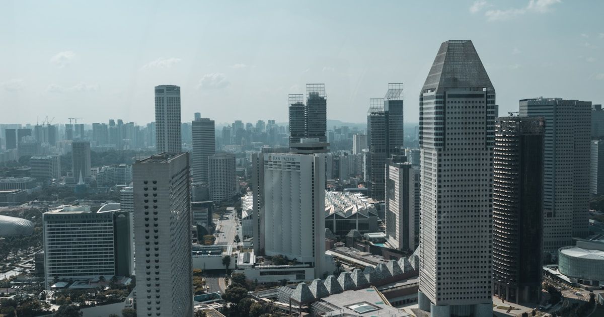 Aerial view of Singapore's central business district showing high-rise office towers including the Pan Pacific Hotel and surrounding city bl