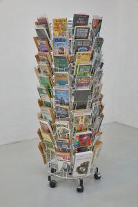 Infinite Summers, 2019, Metal-wire rotating book and postcard stand, plastic and metal roller casters, 96 paperback novels, rubberbands, mirror foil, chair, 145 × 70 × 70 cm (undefined), Mark von Schlegell, Jan Kaps, Cologne