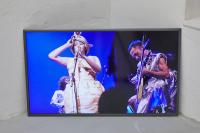 Return of the Lepidopters (detail), 2019, 24 Graphic novels and comics, wood display board, flatscreen television with digital file, plastic and cotton fiber bead curtain in green, neon pink-lit room, chair, Dimensions variable
(undefined), Mark von Schlegell, Jan Kaps, Cologne