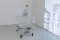 Earth of the Books, 2019, Collection of short stories, plexiglass drink cart, plastic casters, projectors, electrical cables, MP3 player, sound transducers, rubber bands, printed vinyl text, mirror foil, glass, water, 110 × 82 × 66 cm (undefined), Mark von Schlegell, Jan Kaps, Cologne