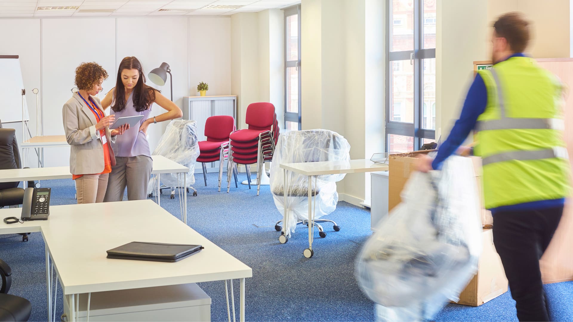 people moving office chairs and other furniture