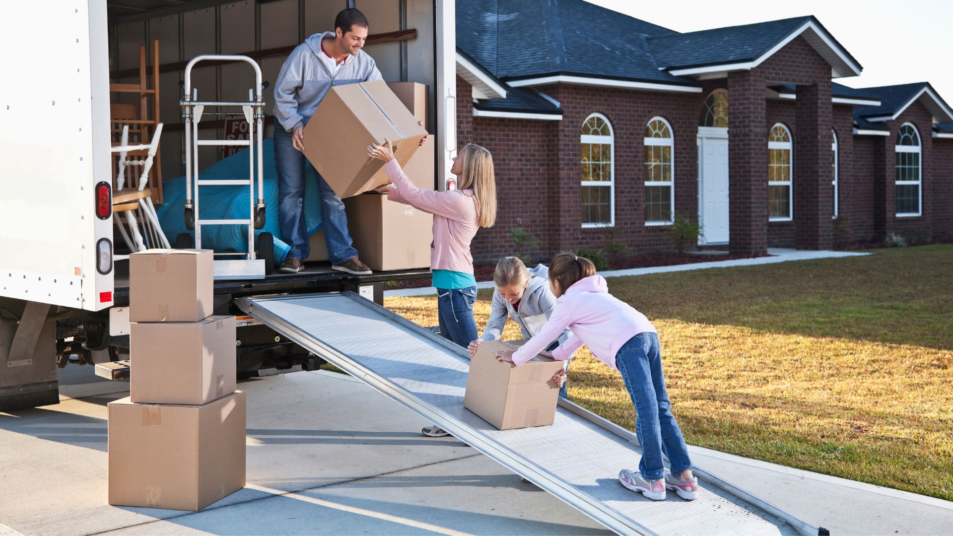 A family moving boxes out of a moving truck