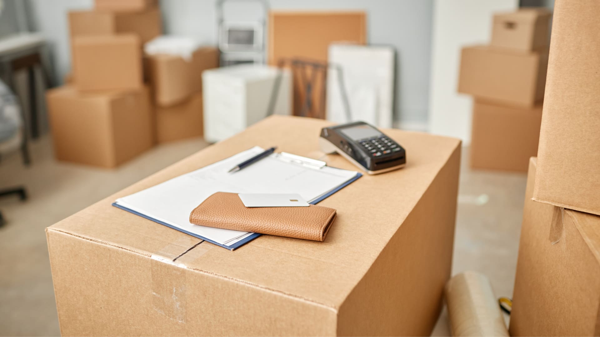 a wallet and clipboard resting on a moving box