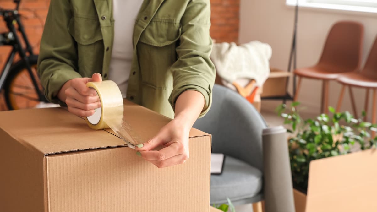 person taping up box for moving