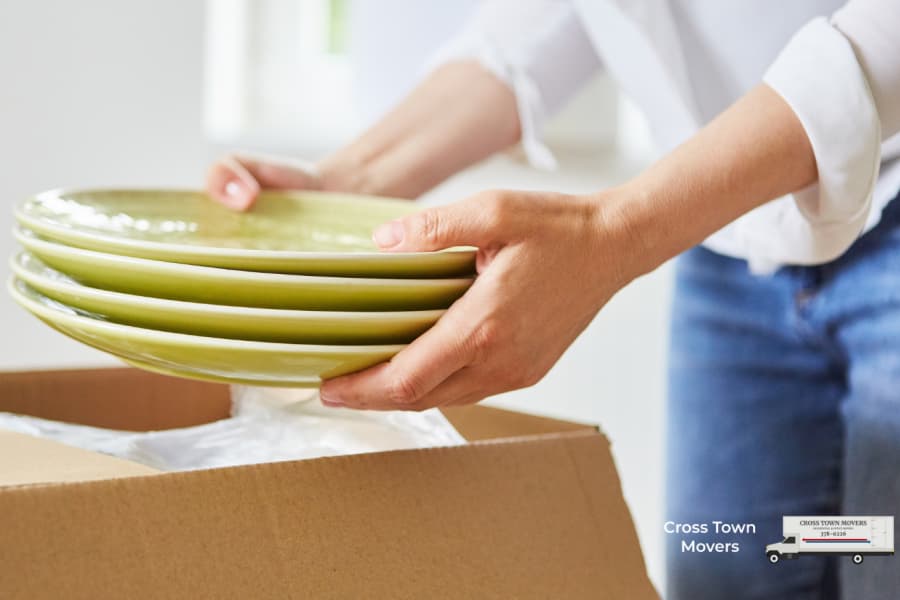 Person putting green plates in a box