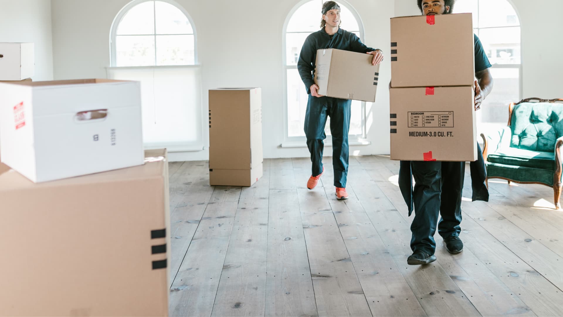 Movers moving boxes into a house