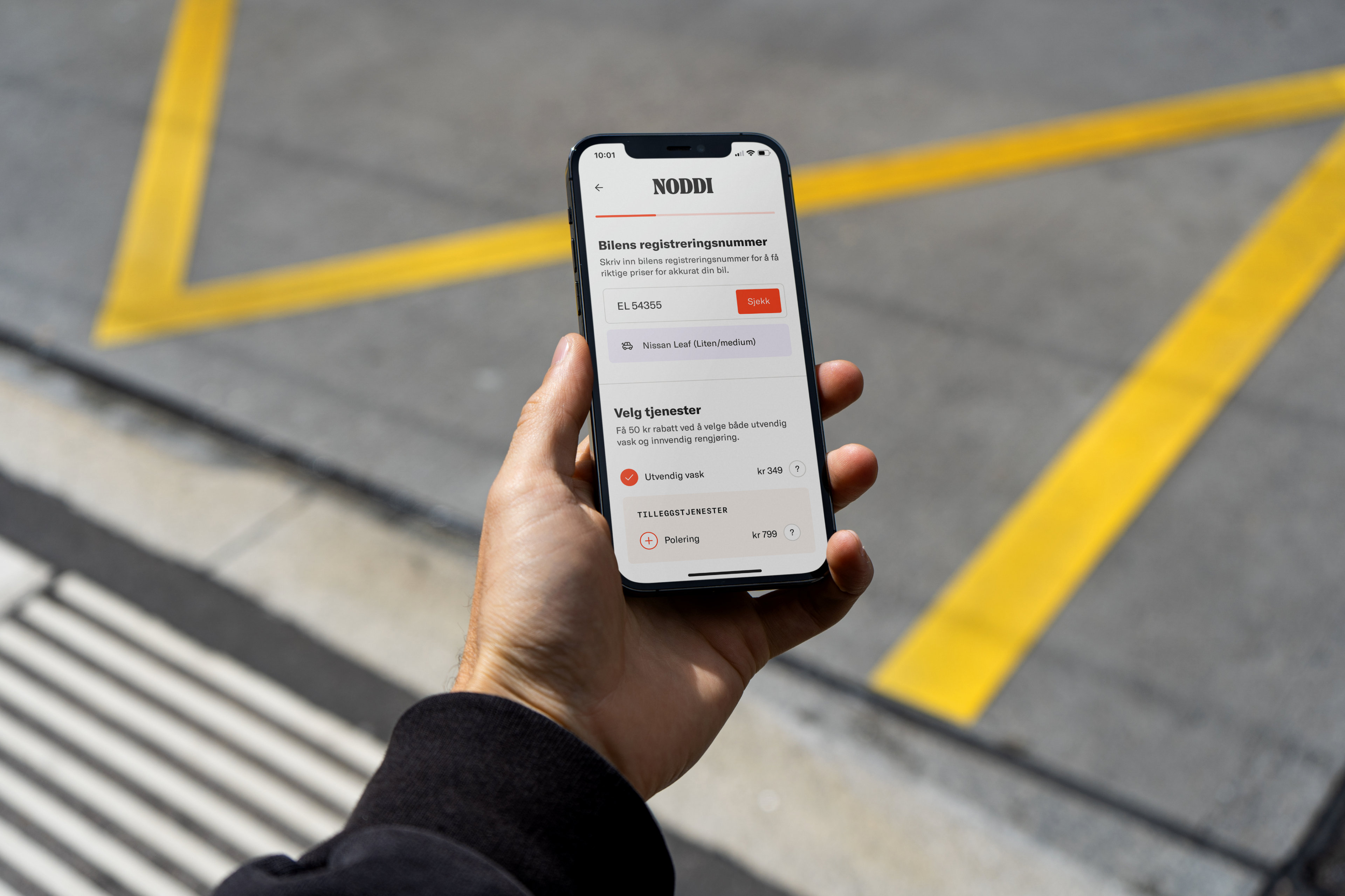 Person som holder mobil i hånden med bilde av brukergrensesnitt