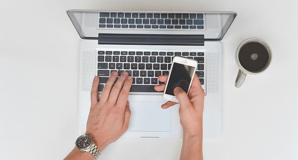 Hender på tastatur og mobiltelefon