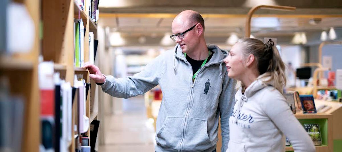 Bibliotekar viser elev bøker