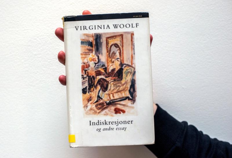 Hånd som holder Indiskresjoner og andre essay av Virginia Woolf