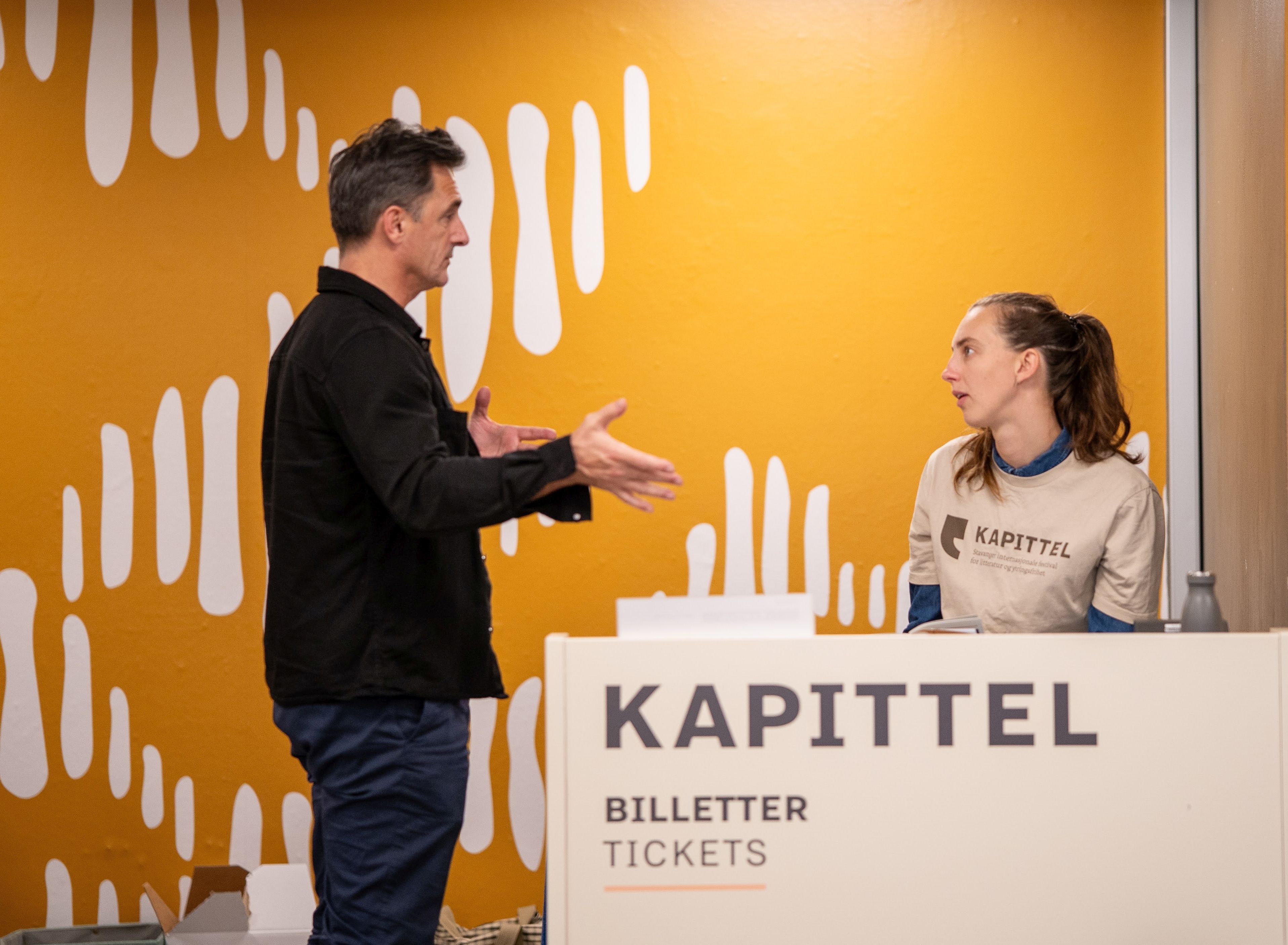 Frivillige og ansatte jobber i billettskranken.  