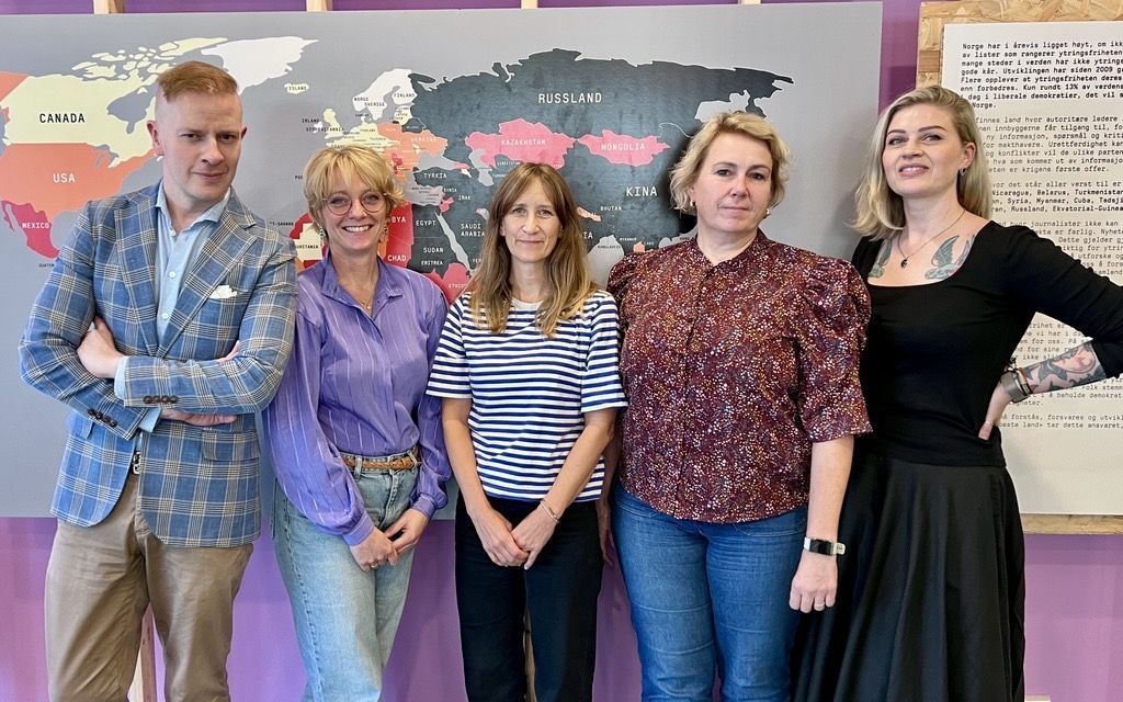 Ansatte på Sølvberget foran et verdenskart i utstillingen Usensurert.