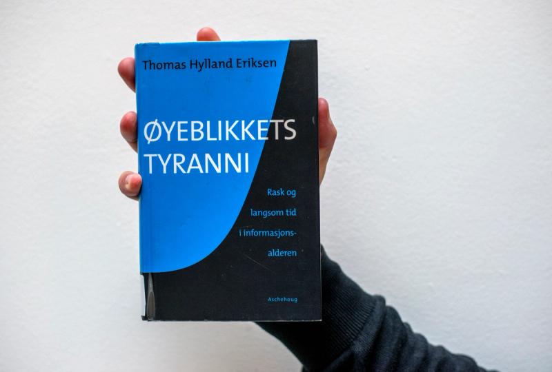 Hånd som holder Øyeblikkets tyranni av Thomas Hylland Eriksen