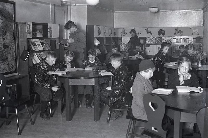 Barn på lesesalen i Stavanger bibliotek. Barn som leser ved runde bord.