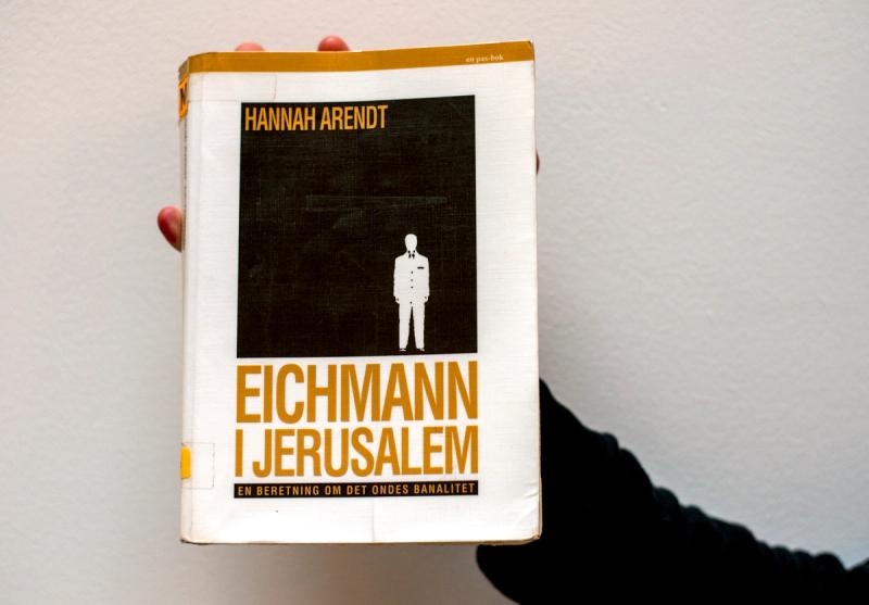 Hånd som holder Hannah Arendts bok Eichmann i Jerusalem