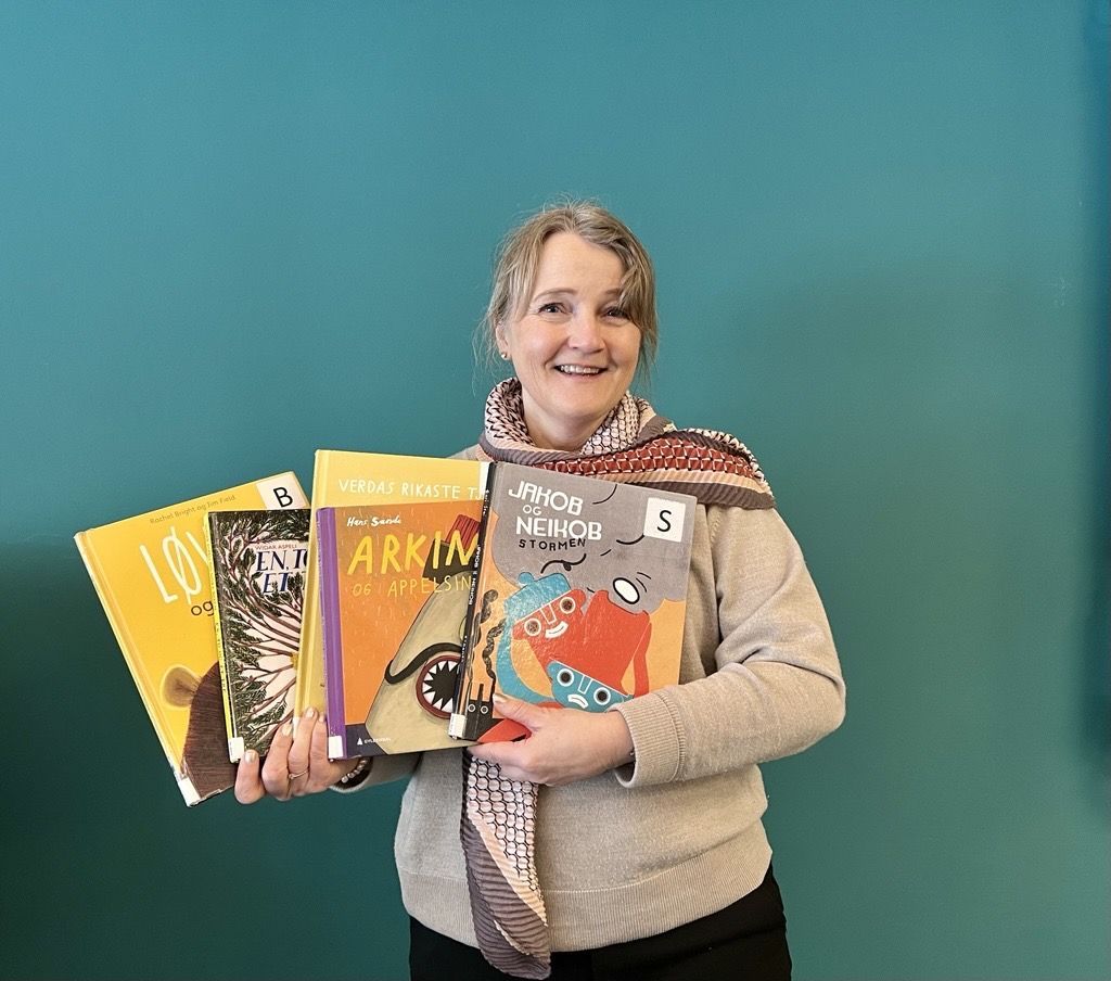Bibliotekar Ingrid Bie Helgesen viser frem barnebøker.