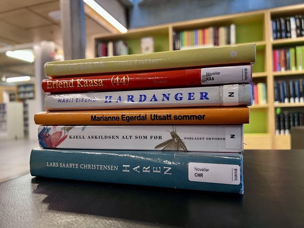 Foto av en stabel med novellesamlinger i biblioteket på Sølvberget.