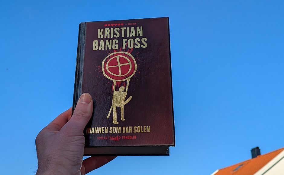 Mannen som bar solen av Kristian Bang Foss holdt foran en blå himmel