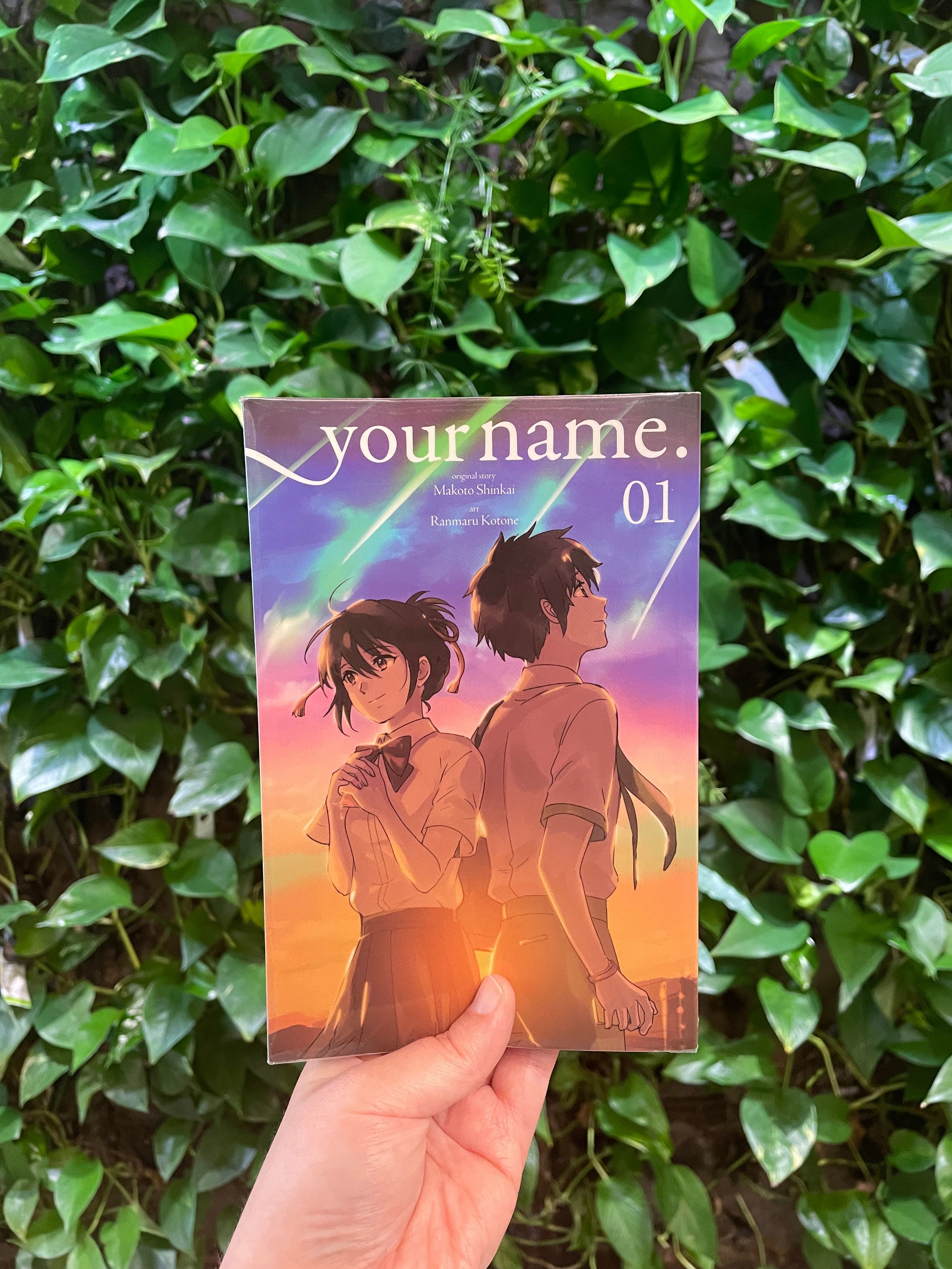 Forsiden til mangaen Your name foran en vegg med blader