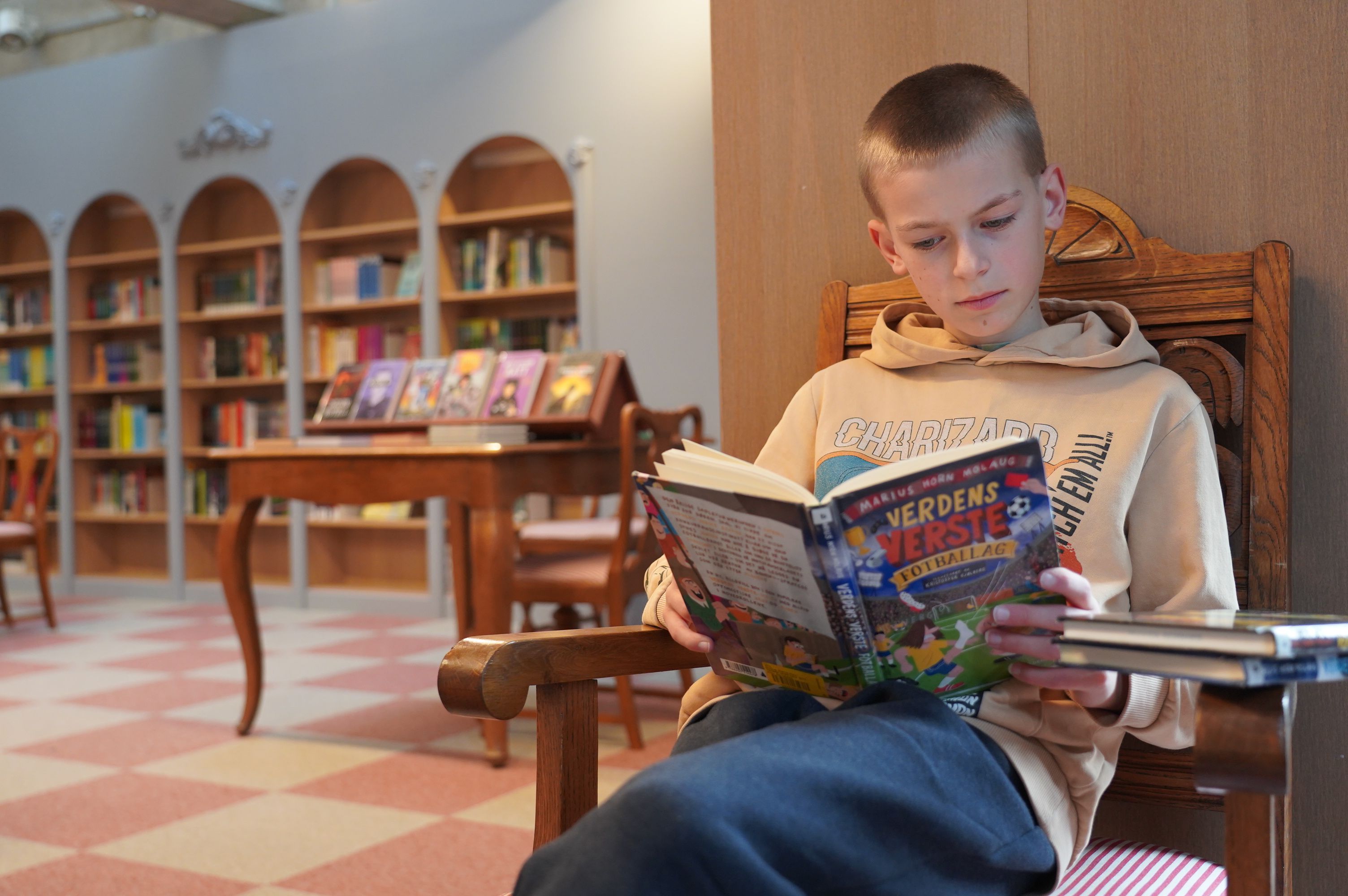 Gutt leser i biblioteket