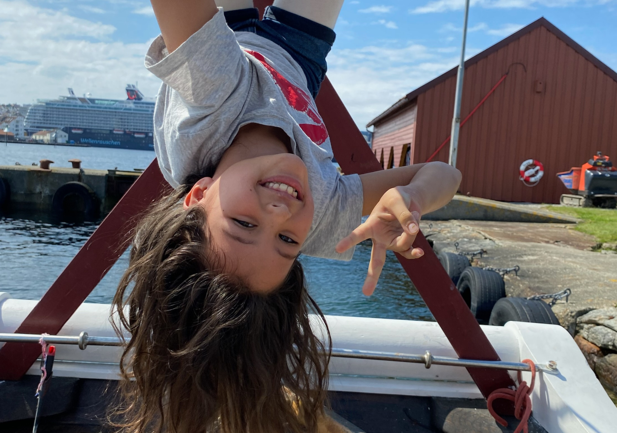 Foto av jente som henger opp ned i en båt