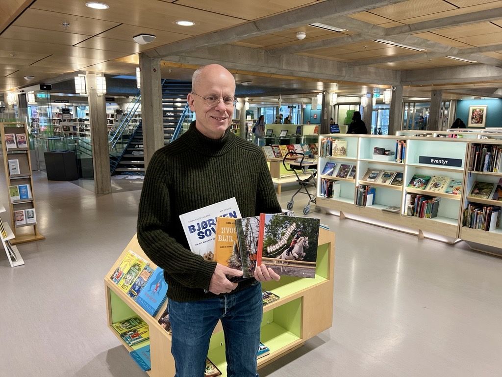 Foto av forfatter Bjørn Arild Ersland med bøker han har skrevet.