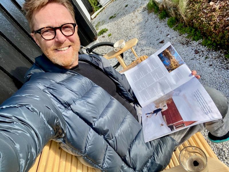John Petter Hernes med magasin og kaffe i hagen