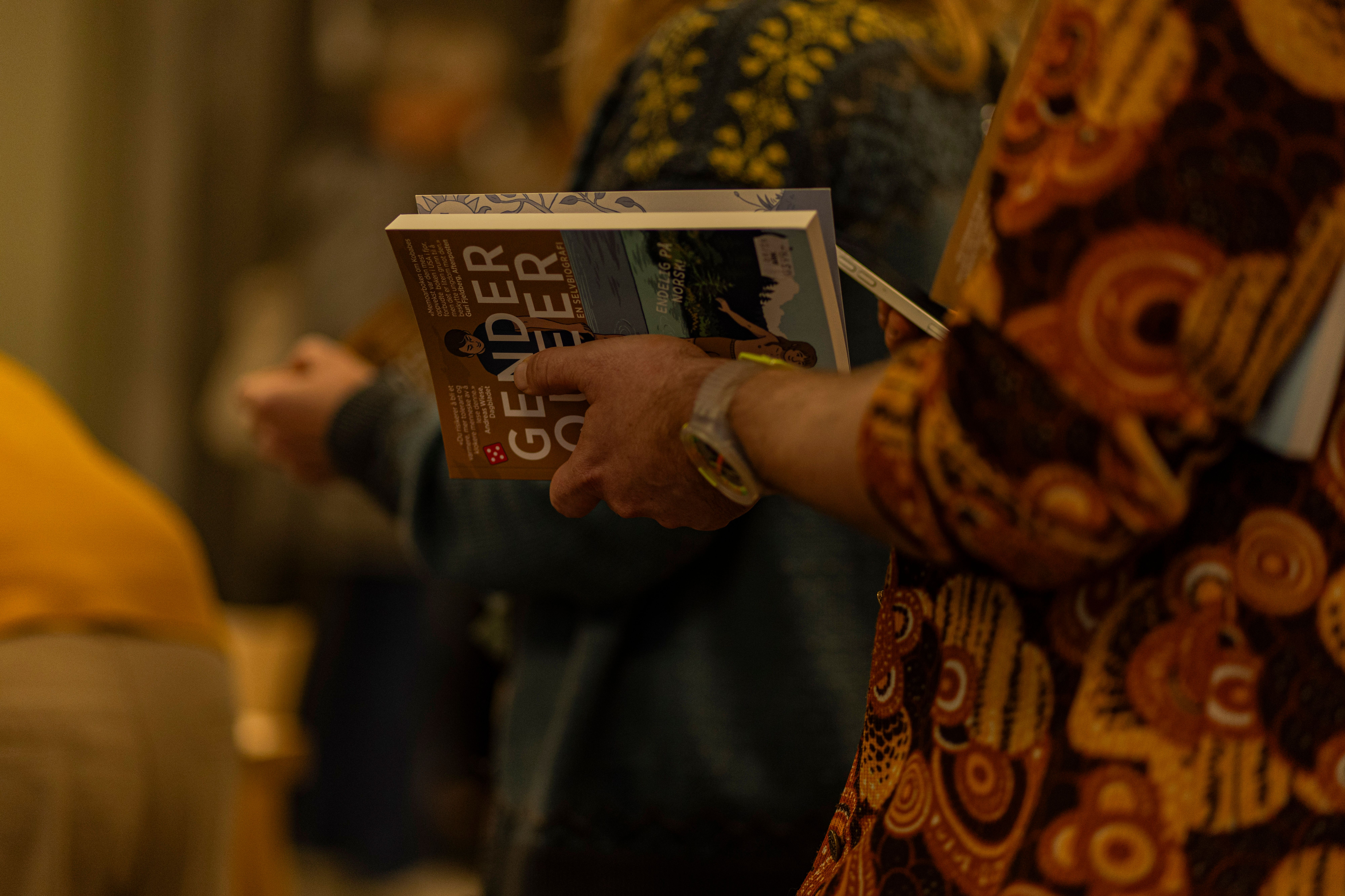 Foto av noen som holder Maia Kobabes bok "Gender Queer". Foto Andrea Rocha. 