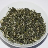 Quality evaluation of wholesale Dongting Biluochun green tea, showing curly dry leaves in a round white bowl.