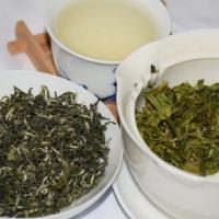Three states of premium Biluochun green tea: curly dry leaves, pale green tea soup, and fresh infused leaves in white teaware.