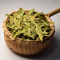 Authentic Dragon Well green tea showing its signature flat and smooth leaves in a small bamboo basket.