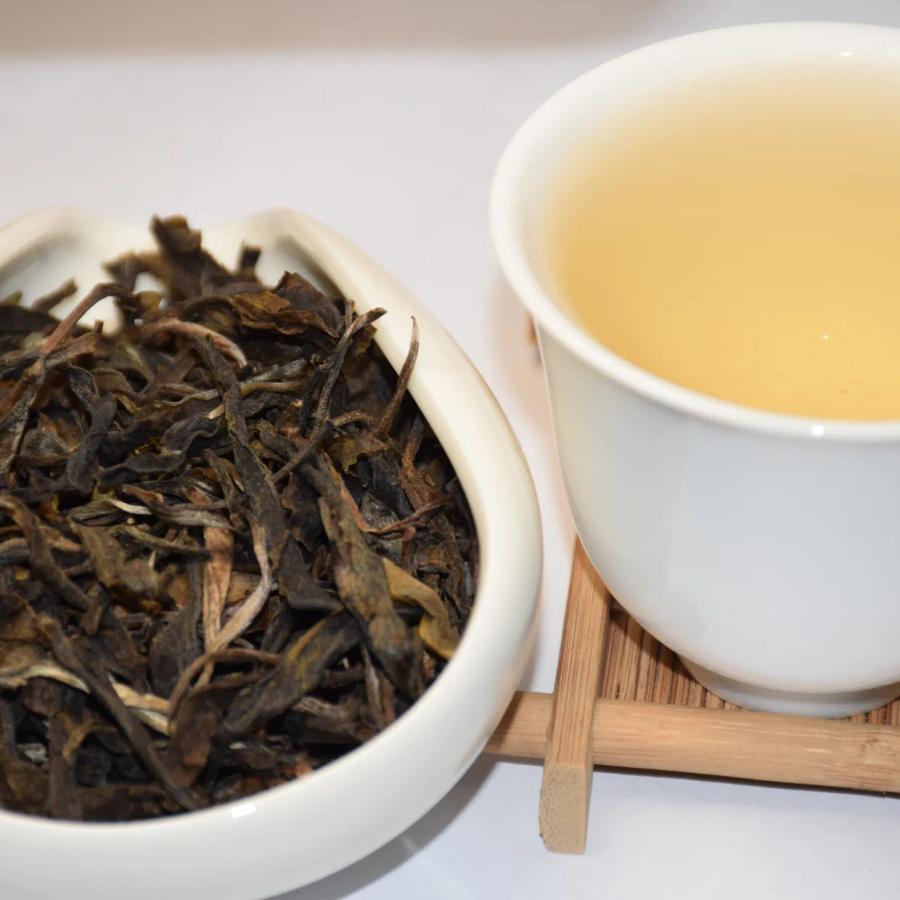 Wholesale EU-compliant raw Pu-erh (Sheng Puerh) tea, featuring premium loose leaves and bright golden liquor.