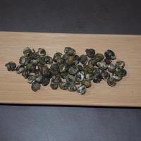 Wholesale Jasmine Dragon Pearl green tea, displaying premium hand-rolled tea pearls on a natural bamboo tray.