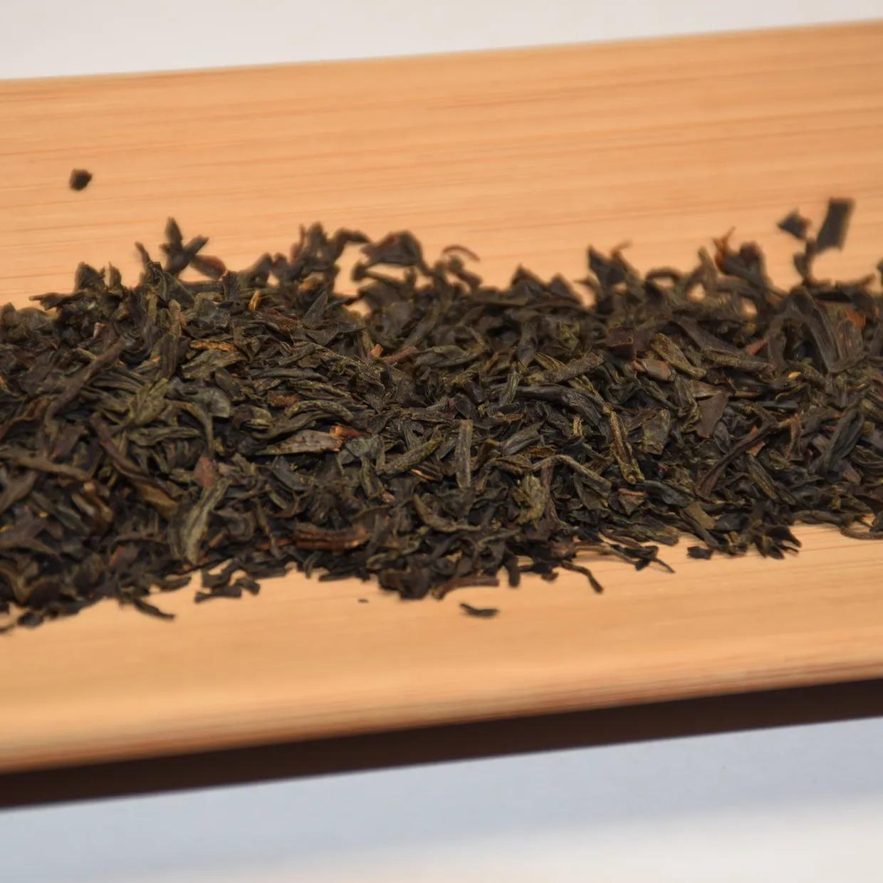 Tightly twisted Keemun gongfu dry leaves on a bamboo tray