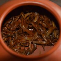 Quality evaluation of Shaoguan Honey Black Tea, showing tender and bright coppery wet leaves inside a teapot.