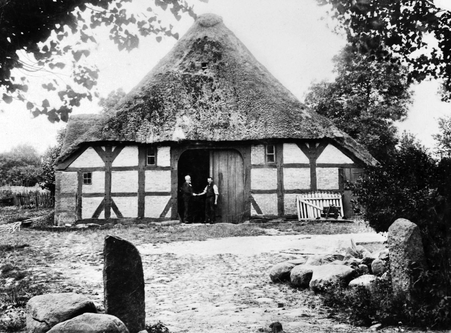 Gammelt sort/hvid foto af Bernhard Olsen der giver hånd til en anden i døren