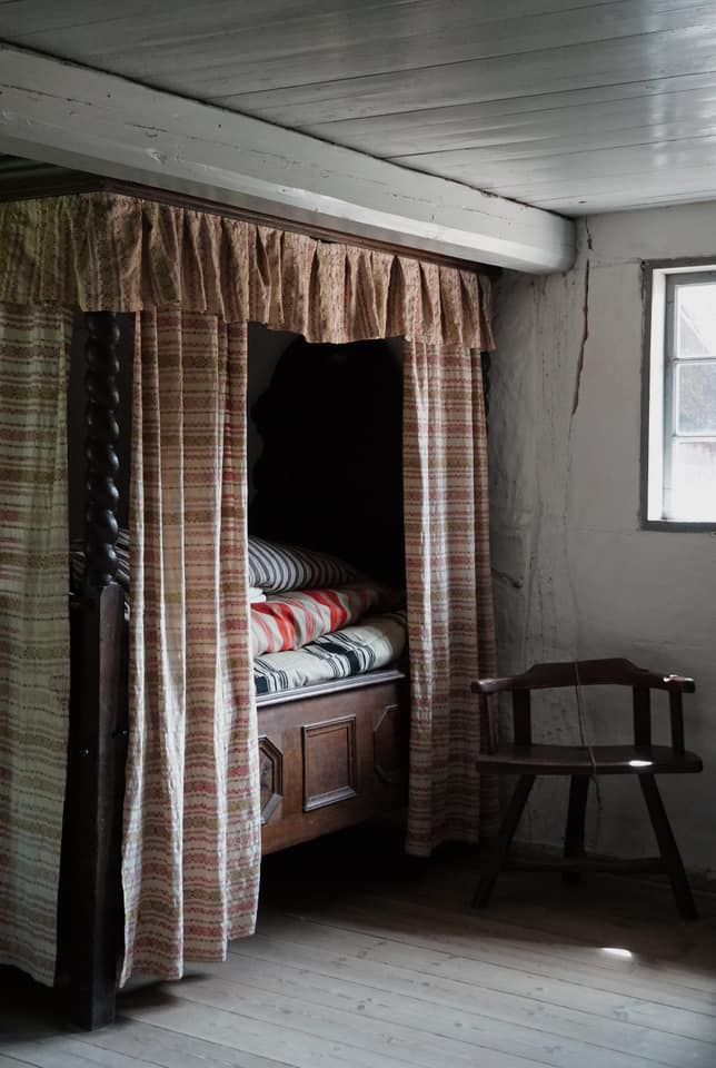 An alcove with striped curtains and duvets from a bedroom in the historic farmhouse from Dannemare on Lolland. The house is from around 1850.