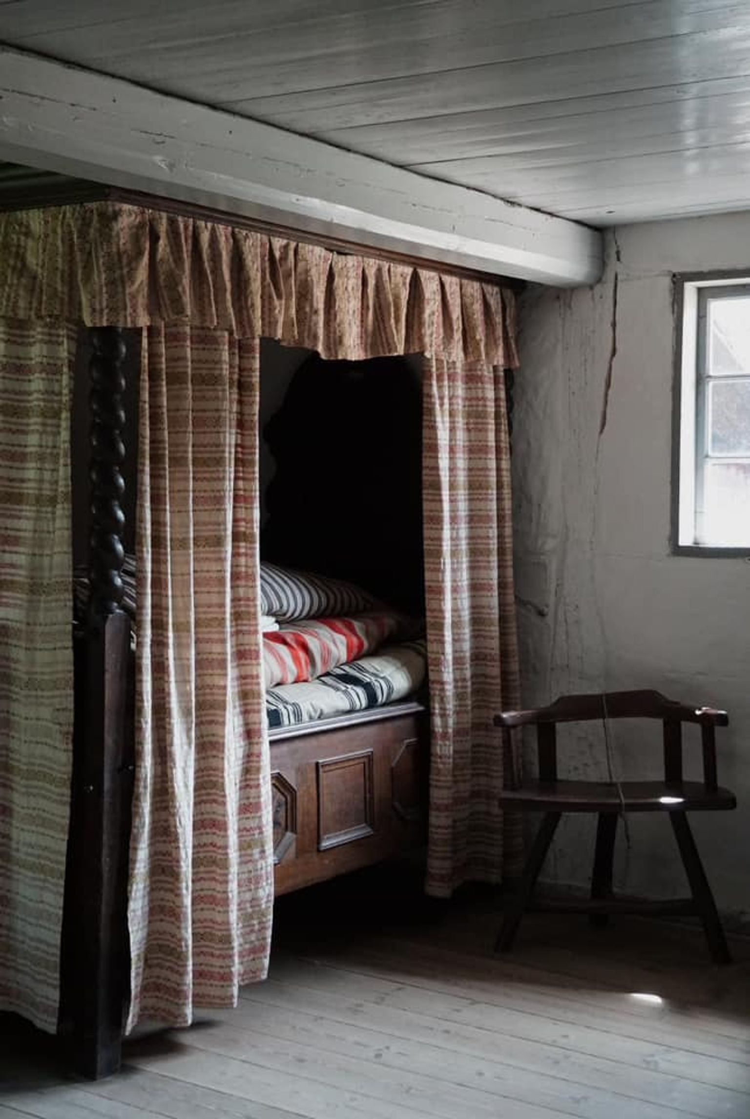 An alcove with striped curtains and duvets from a bedroom in the historic farmhouse from Dannemare on Lolland. The house is from around 1850.